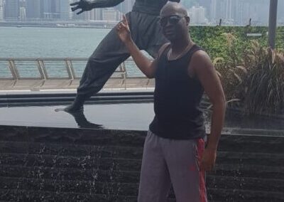 Sifu Ryan posing in front of Bruce Lee whilst training in Hong Kong